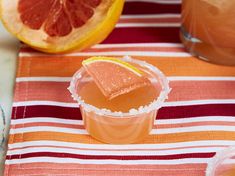 a grapefruit cocktail with orange slices and garnish on a striped table cloth