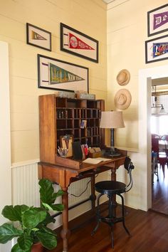 a room with a desk, chair and pictures on the wall