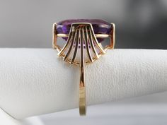 This stunning vintage Amethyst ring has a rich, bright purple Amethyst in the center that flashes and flickers with vibrant violet reflections! Set into a lovely vintage mounting with winged wire work, this ring makes a bold statement! Metal: 14K Yellow Gold Gem: Amethyst Gem Measurements: 12.5 x 16.8 mm, Oval Ring Size: 8.25 SKU #: 33488M70 Each piece has been identified and graded by a Graduate Gemologist who has been certified by the Gemological Institute of America (GIA). We have four brick Luxury Multi-stone Amethyst Ring In Yellow Gold, Antique Gold Amethyst Ring With Multi-stone, Luxury Gold Multi-stone Amethyst Ring, Elegant Multi-stone Amethyst Collectible Ring, Gold Amethyst Ring, Fine Jewelry Collectible, Yellow Gold Amethyst Ring, Yellow Gold Sapphire Ring, Amethyst Ring Vintage, Amethyst Cocktail Ring