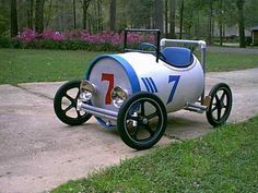 an old fashioned pedal car is parked on the sidewalk