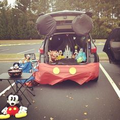 the back of a car with mickey mouse decorations on it's trunk and other items