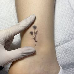 a woman's foot with a small flower tattoo on her left side calfocks