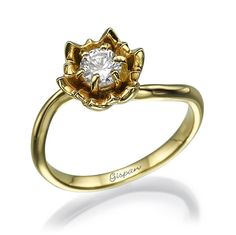 a gold ring with an orange and white diamond in the center