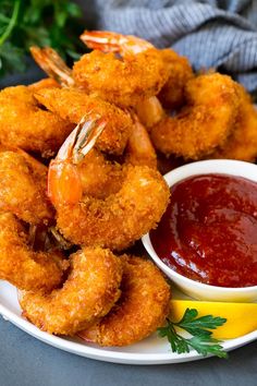 fried shrimp and dipping sauce on a white plate