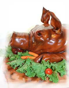 a sculpture of a pig laying on top of lettuce and carrots in it's mouth