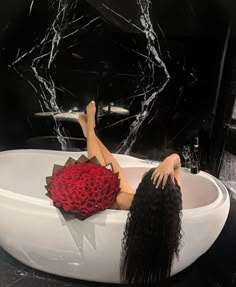 a woman laying in a bathtub with her legs up