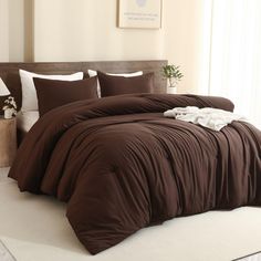 a bed with brown sheets and pillows in a room