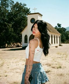 a woman with tattoos standing in front of a church