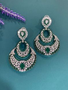 American diamond earring tikka set in black Victorian polish. Comes with a tikka. Available in 3 different color. Two of which is black polished . One set has ruby retails and one is clear. about 3 inch long and one and half in width. Tikka is about one inch long. Elegant Hand Set Cubic Zirconia Chandbalis, Green Hand-set Chandbalis For Party, Traditional Diamond Round Chandelier Earrings, American Diamond Drop Earrings With Stone Work, Silver Round Chandelier Earrings For Reception, Elegant Round Chandelier Earrings With Stone Work, Elegant Hand Set Diamond Chandbalis, Elegant Round Bridal Earrings With Stone Work, Round Hand Set Chandelier Earrings For Reception