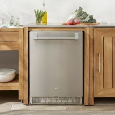 a stainless steel dishwasher sitting on top of a wooden cabinet in a kitchen