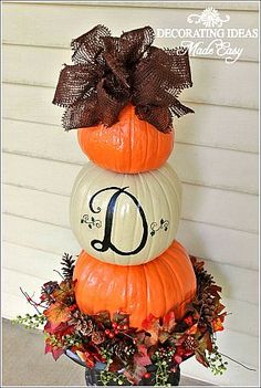 three pumpkins stacked on top of each other with the letter d painted on them