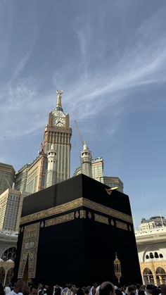 a group of people standing around a large black object in the middle of a city