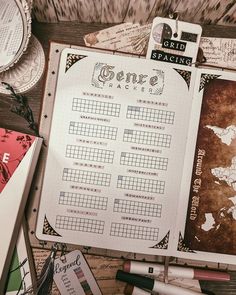 an open notebook sitting on top of a wooden table next to some pens and paper