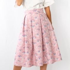 a woman wearing a white shirt and pink skirt