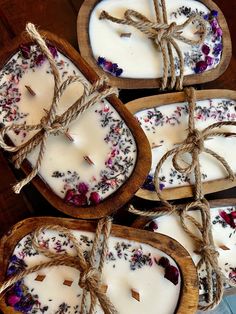 four wooden trays filled with candles tied up to each other on top of a table