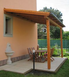 an outdoor patio with table and chairs under a pergolated area next to a building