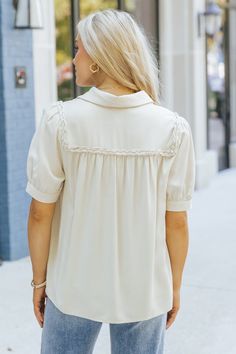 Add a touch of texture and elegance to your everyday wardrobe with the Braided Button Down Top! This effortlessly chic top blends classic design with unique boho-inspired details, making it a versatile must-have. Featuring intricate braided trim detail, this top elevates a simple look with subtle, eye-catching texture. Whether paired with jeans, skirts, or layered under a jacket, this top is the perfect blend of casual and boho chic, making it a go-to piece for any occasion. Chic Solid Blouse With Collared Neckline, Chic Solid Color Blouse With Collared Neckline, Versatile Collared Rayon Blouse, Beige Bohemian Tops With Buttons, Beige Bohemian Top With Buttons, Spring Viscose Blouse With Buttons, Chic Tops With Collared Neckline And Button Closure, Feminine Collared Blouse With Buttons, Feminine Blouse With Collared Neckline And Buttons