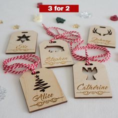 wooden tags with christmas designs on them sitting next to other ornaments and confetti