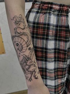 a woman's arm with a dragon tattoo on the left side of her right arm