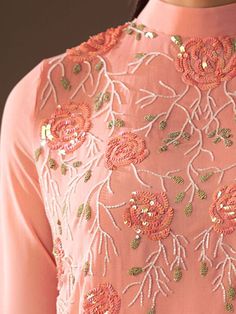 the back of a woman's pink dress with flowers and sequins on it