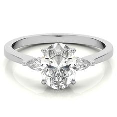 a white gold engagement ring with three diamonds on the band and an oval cut diamond in the center