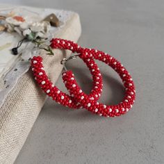 Stylish red and white polka dot beaded hoop earrings. ♥ SIZE (approximately diameter) : 1.1 inch 1.4 inch 1.6 inch 2.2 inch  ♥ 100% handmade ♥ Packed in gift box ♥ Very light ♥ If you like this item in a different color - send me a message, please. Feel free to communicate with me Advice on use and care * Never wear any jewelry while bathing or showering. Chlorine can cause damage. Please do not swim and did not take a shower in beaded jewelry * Try to avoid the drop, shock and compression of jewelry from beads Since this is handmade item, every new good may be vary slightly, but the overall look will match that shown on the photo. You can see more hoop earrings in my shop https://www.etsy.com/shop/IvonaHMJewelry?ref=seller-platform-mcnav&section_id=22254200 Hoop Earrings Big, Polka Dot Earrings, Dot Earrings, Earrings Big, Handmade Beaded Jewelry, Earrings Red, Beaded Hoop Earrings, Red Polka Dot, Beaded Hoops