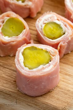 several pieces of ham with pickles in the middle