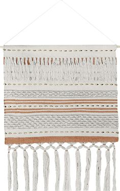 a white wall hanging with tassels on it