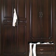 a wooden armoire with two white towels hanging from it's handles and drawers