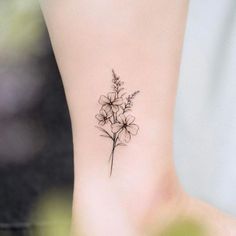 a small flower tattoo on the ankle that is black and white with some flowers in it