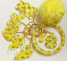 a yellow keychain with charms and a pom - pom