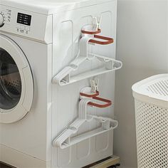 a white washer and dryer sitting next to each other in front of a laundry basket