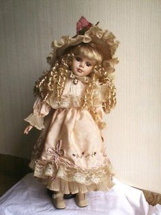 the doll is wearing a dress and hat with ruffles on it's head