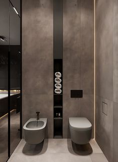 a modern bathroom with two toilets in it