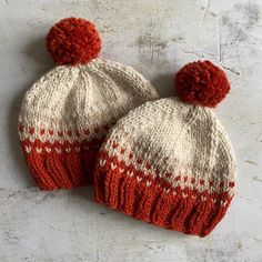 two red and white knitted hats sitting next to each other