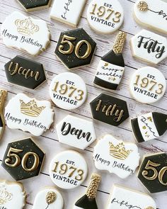 decorated cookies are arranged in the shape of 50th birthday signs and numbers on white wood planks