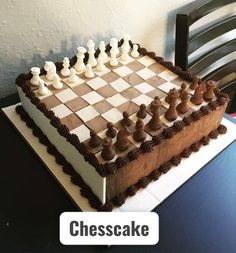 a cake shaped like a chess board with white and brown pieces on it sitting on a table