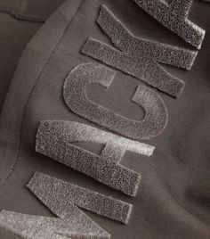 the back of a black jacket with silver letters on it