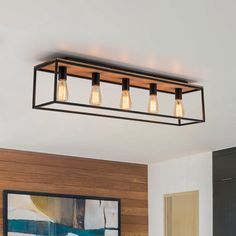 a light fixture with three lights hanging from it's ceiling in a living room