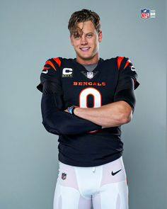 a football player is posing for a photo with his arms crossed in front of him