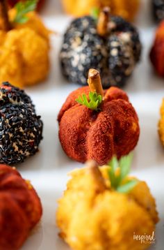 small pumpkins with sprinkles and leaves on them are arranged in rows