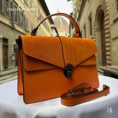 This bag has been made of the best genuine leather by local master crafters of Florence in Italy, designed for women who only accept premium Italian quality and luxury leather bags and modern Italian fashion. . Sizes: Width: 29cm/10.6 inch Height: 19cm/7.4 inch Depth: 7 cm/3.9 inch The story of this bag :  In the heart of Florence, Italy, where the legacy of art and craftsmanship intertwines with the modern world, a master artisan named Sofia was crafting a piece of pure elegance - a Luxury Leather Bag like no other. This red leather bag wasn't just a fashion accessory; it was an embodiment of Italy's rich heritage in leatherwork, meticulously handmade with genuine leather. Sofia's dedication to her craft was unparalleled, and her creations were nothing short of masterpieces. Her workshop Elegant Orange Leather Shoulder Bag, Orange Textured Leather Shoulder Bag, Leather Flap Bag With Smooth Grain For Daily Use, Luxury Flap Bag With Smooth Grain For Daily Use, Daily Use Leather Flap Bag With Smooth Grain, Orange Textured Leather Bag, Leather Flap Bag For Work, Luxury Leather Flap Bag For Daily Use, Soft Leather Flap Bag For Workwear