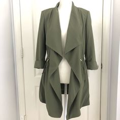 3/4 Sleeve Jacket Adjustable String To Enhance And Flatter Your Waist Line, Gold Metal To Hold On Place String. Very Classic Long Coat, Blazer Style With Drape Effect In The Front. Pockets On Both Sides. Neutral Olive Color, To Wear All Year Round. Mannequin Has Size Small On. Brand New Green Open Front Outerwear For Layering, Olive Long-sleeved Blazer For Spring, Green Open Front Outerwear For Spring, Khaki Spring Outerwear For Office, Olive Long Sleeve Blazer For Spring, Spring Khaki Outerwear For Office, Olive Long Sleeve Outerwear For Work, Green Spring Office Outerwear, Fitted Olive Long Sleeve Outerwear