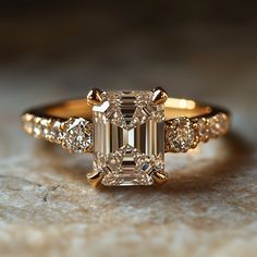 an engagement ring with a fancy emerald cut diamond surrounded by smaller round diamonds on the band