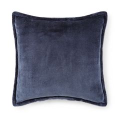 a blue velvet pillow on a white background