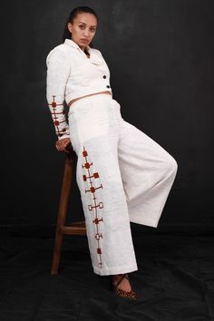 Embracing Heritage in Style: This exquisite Habesha dress seamlessly blends traditional Ethiopian design elements with a modern fashion sensibility, embodying the essence of Habesha libs and Ethiopian dress. The white base of the dress beautifully contrasts with intricate brown cross-stitch patterns, meticulously adorning the sleeves, waist, and pants. With its high neckline and long sleeves, this dress exudes elegance, offering a perfect fusion of Habesha kemis and contemporary trends. Ideal for those who cherish the richness of Habesha culture and aspire to make a bold fashion statement. Festive Fitted Habesha Kemis With Embroidery, Fitted White Embroidered Habesha Kemis, Crop Top Coat, Luxury Festive Women's Habesha Kemis, Festive Traditional Habesha Kemis With Woven Motifs, Dress Crop Top, Habesha Culture, Festive Folk-style Habesha Kemis, Habesha Dress