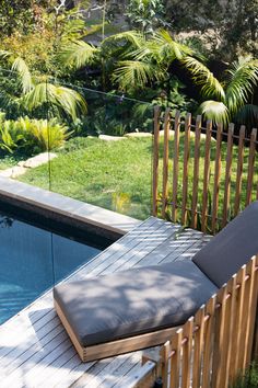 a wooden bench sitting next to a swimming pool