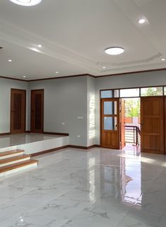 an empty room with marble flooring and wooden trimmings on the doors, windows, and stairs