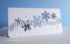 a white card with blue snowflakes and the word merry christmas written in it