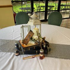 a table topped with books and candles on top of a white table cloth covered table